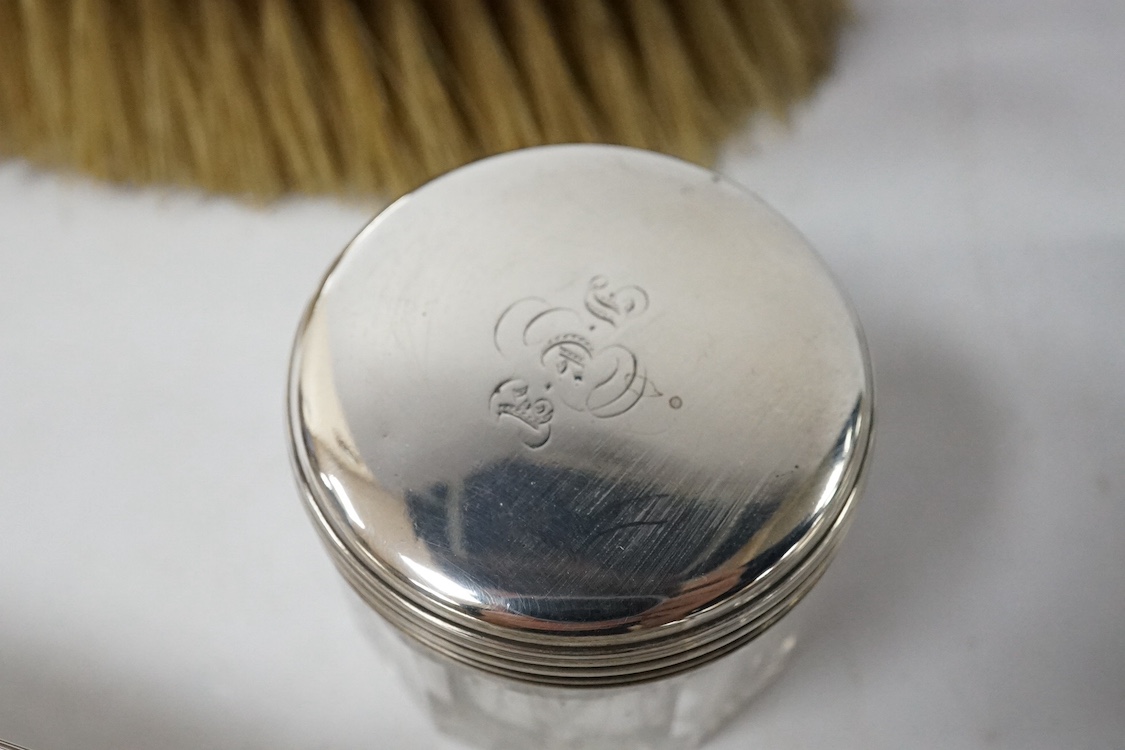 A 19th century Dutch white metal octagonal vinaigrette, with engraved geometric decoration, 51mm, together with two William IV silver mounted glass toilet jars, George Reid, London, 1834, one other later silver mounted g